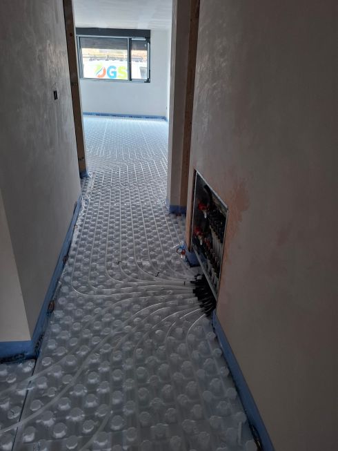Instalación de suelo radiante con colector hidráulico en vivienda en obra.