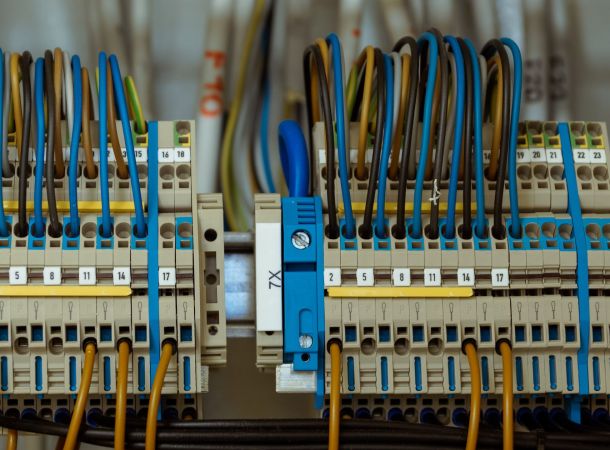 Detalle de instalación eléctrica con bornas de conexión y cables codificados por colores.
