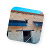 Paneles solares instalados en la fachada de una casa de piedra rústica.